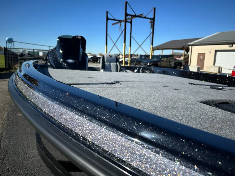 Slide: The Image of 2025 Phoenix 21 XE boat with sleek design and metallic finish, parked outdoors. - 13