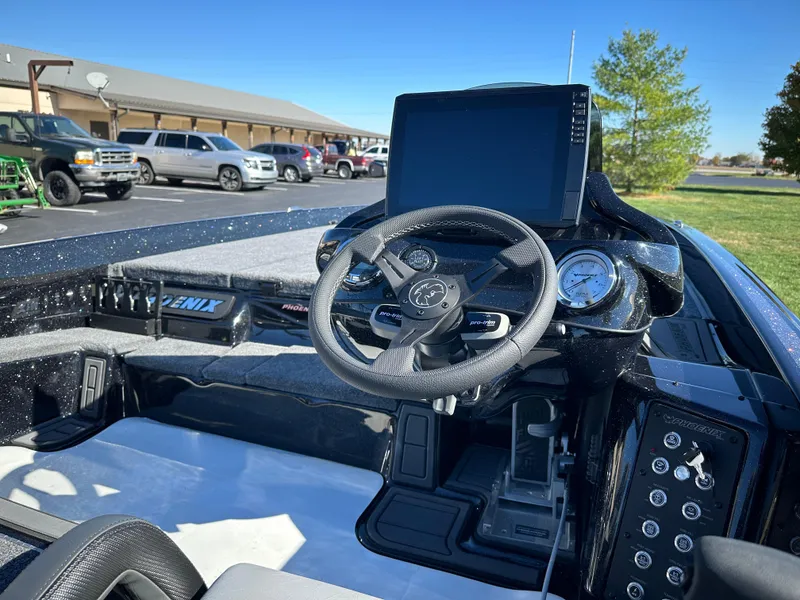 Slide: The Image of 2025 Phoenix 21 XE boat dashboard with steering wheel and digital display. - 17