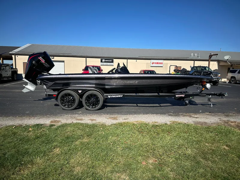 Slide: The Image of 2025 Phoenix 21 XE boat on trailer, parked outdoors under clear blue sky. - 5
