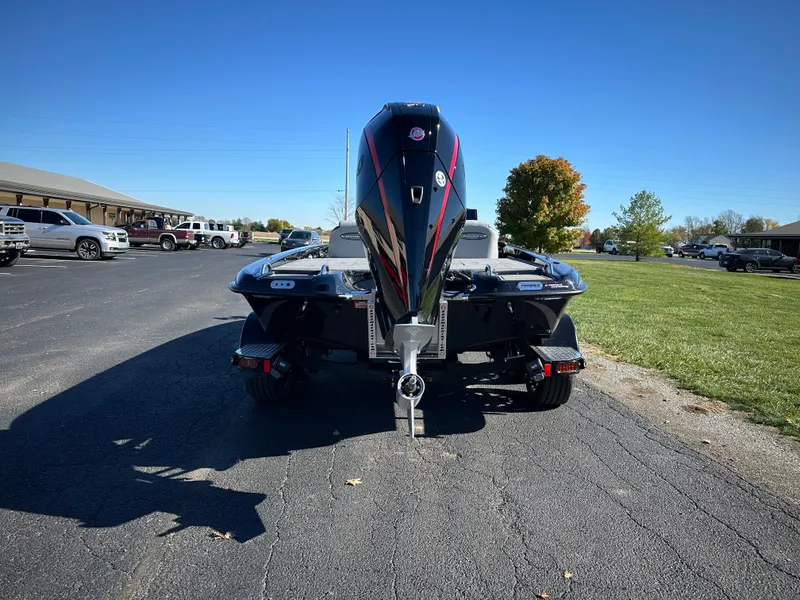 Slide: The Image of Phoenix 21 XE 2025 boat on trailer, parked on asphalt near grassy area. - 7
