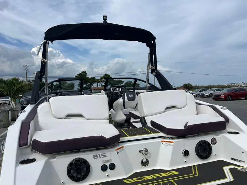 Slide: The Image of 2020 Scarab 215ID boat with white seating and black canopy, parked outdoors. - 11