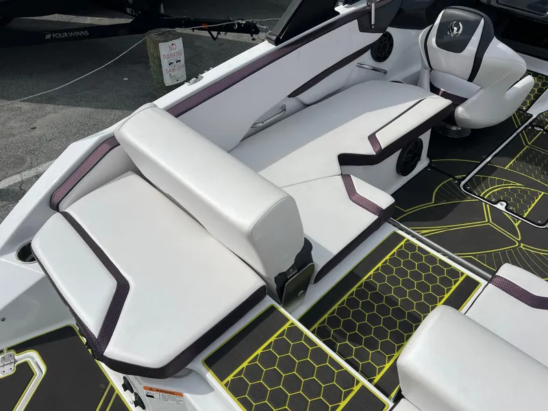 Slide: The Image of 2020 Scarab 215ID boat interior with white seating and hexagonal floor design. - 13