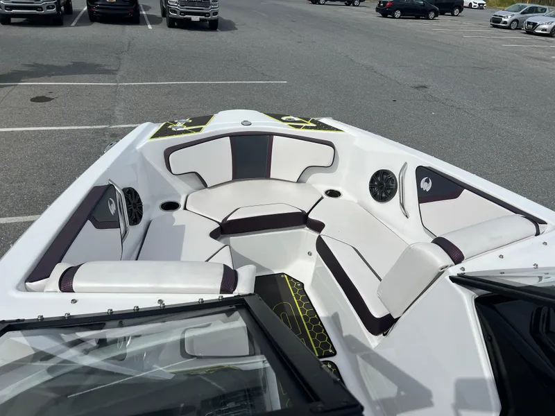 Slide: The Image of 2020 Scarab 215ID boat interior with white and black seating in a parking lot. - 5