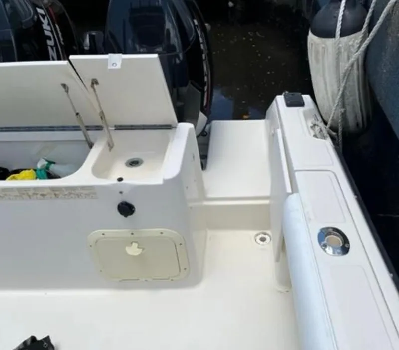 Slide: The Image of 1995 Pursuit 2470 boat deck with storage compartments and Suzuki outboard motor. - 13