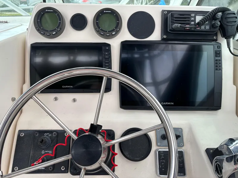 Slide: The Image of Boat dashboard with Garmin displays and steering wheel, Pursuit 2470, 1995 model. - 17