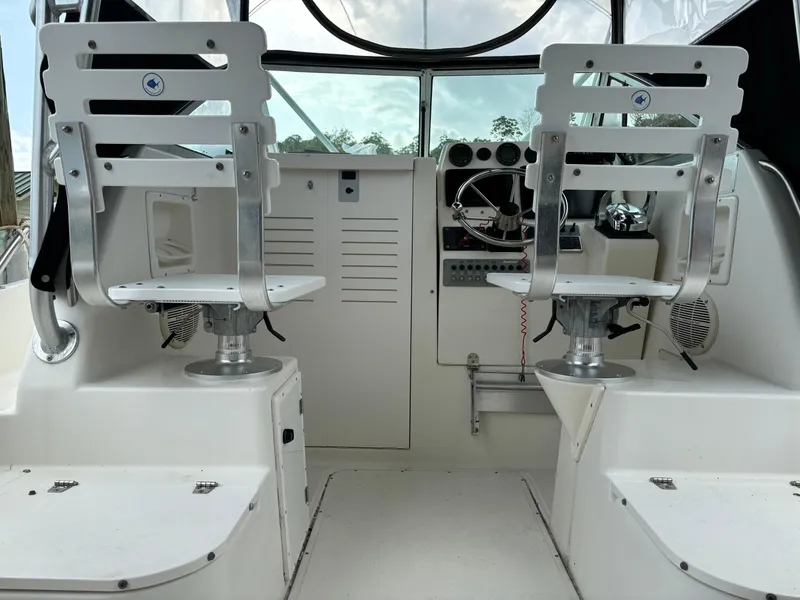 Slide: The Image of Interior of a 1995 Pursuit 2470 boat showing helm and seating area. - 18