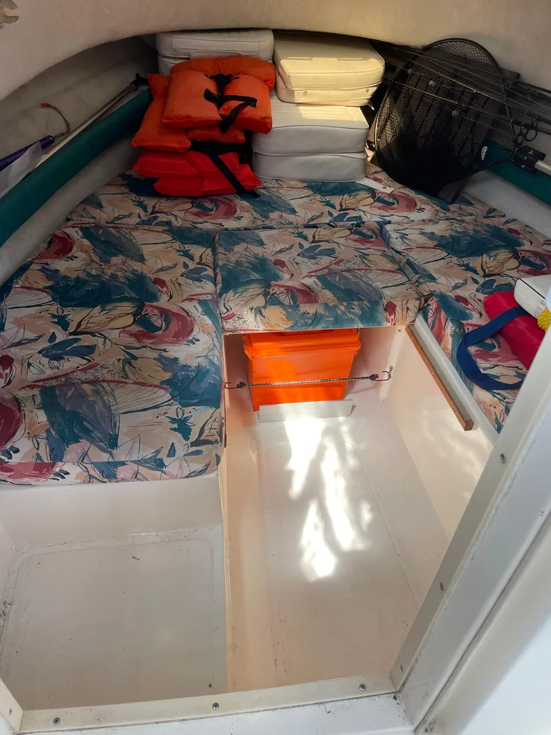 Slide: The Image of Interior of a 1995 Pursuit 2470 boat with floral cushions and safety gear. - 20