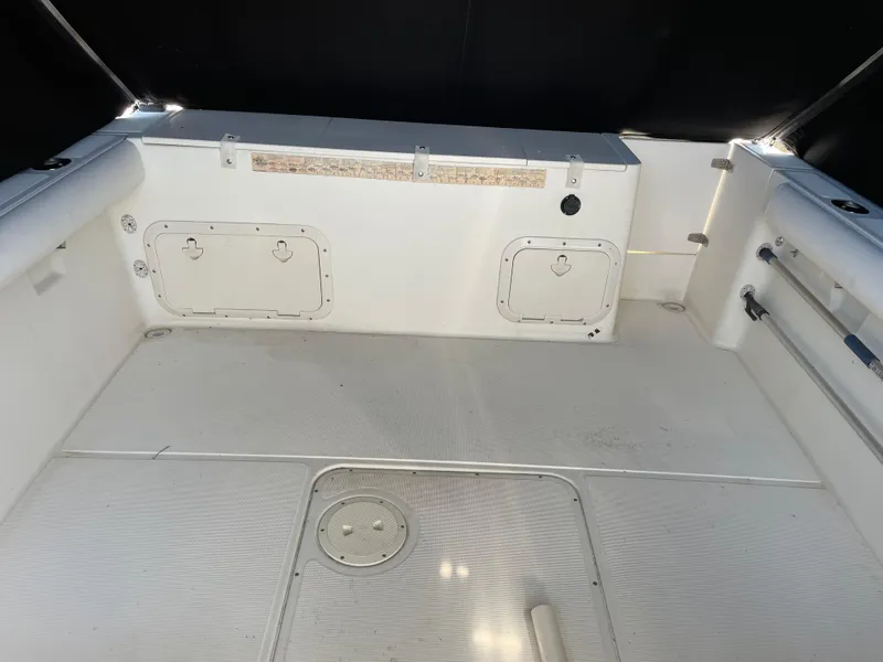 Slide: The Image of 1995 Pursuit 2470 boat interior with storage compartments and clean deck. - 22