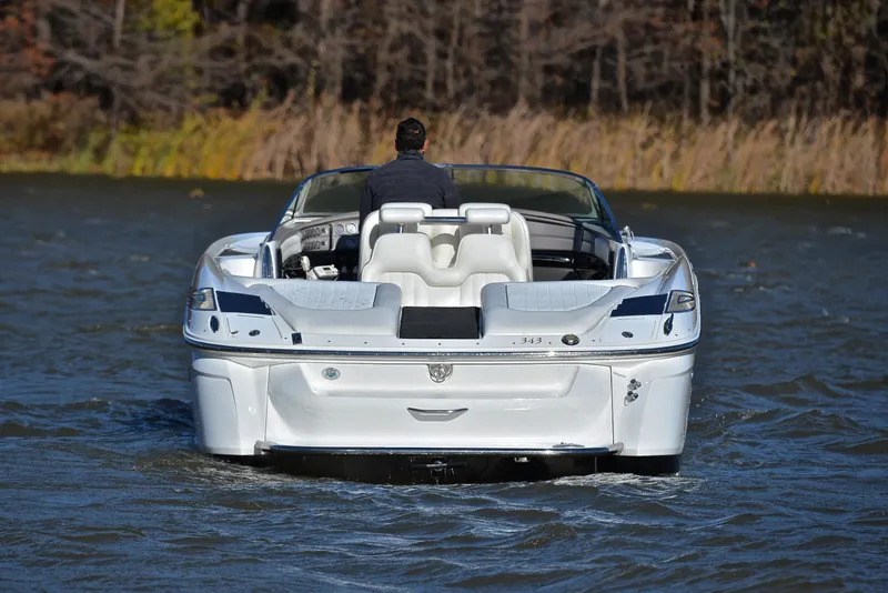 Slide: The Image of 2005 Cobalt 343 boat cruising on a lake with a person at the helm. - 11