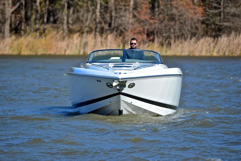 Slide: The Image of Man piloting 2005 Cobalt 343 boat on a lake with forested background. - 12