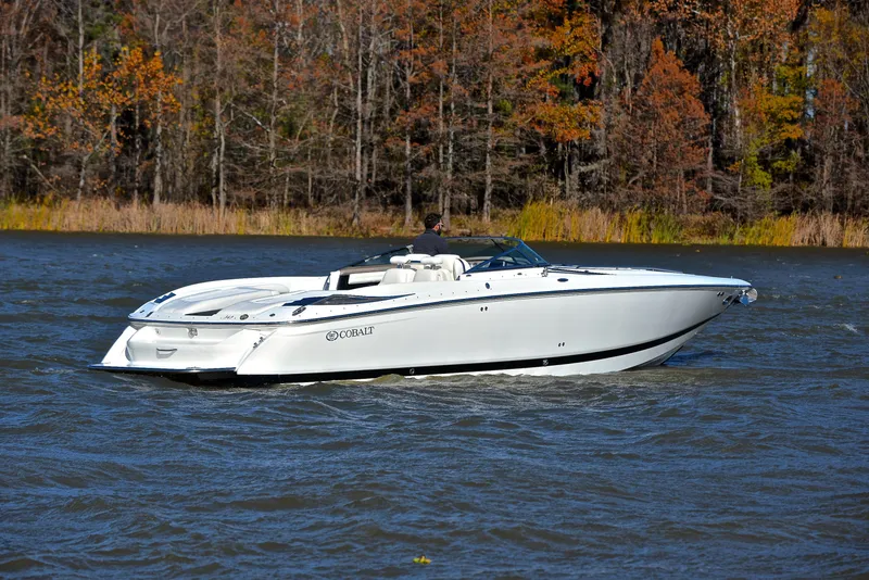 Slide: The Image of 2005 Cobalt 343 boat cruising on a lake with autumn trees in the background. - 13