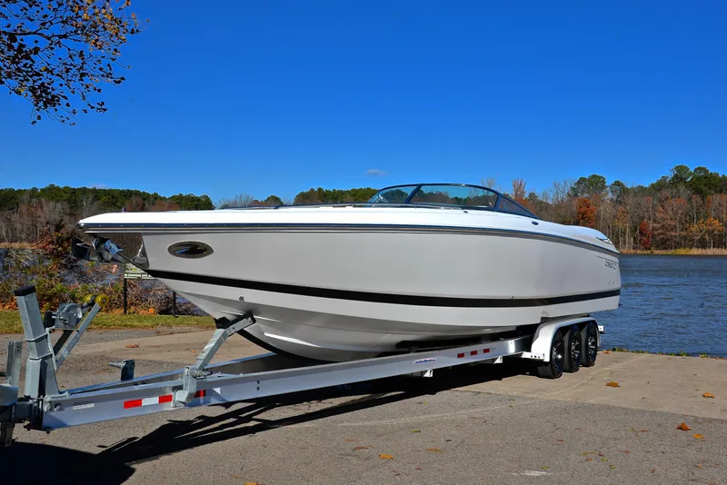 Slide: The Image of 2005 Cobalt 343 boat on trailer by a lake under clear blue sky. - 14