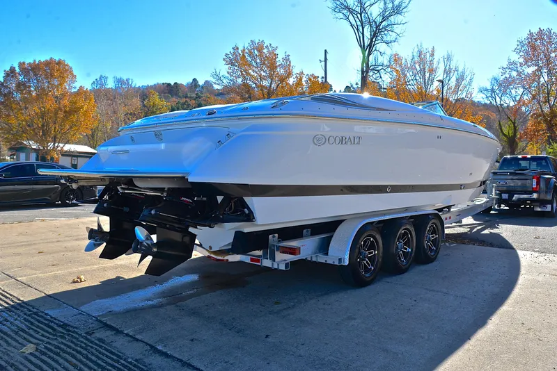 Slide: The Image of 2005 Cobalt 343 boat on trailer, parked outdoors in sunny autumn setting. - 18