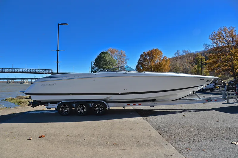 Slide: The Image of 2005 Cobalt 343 boat on trailer by river, clear blue sky. - 19