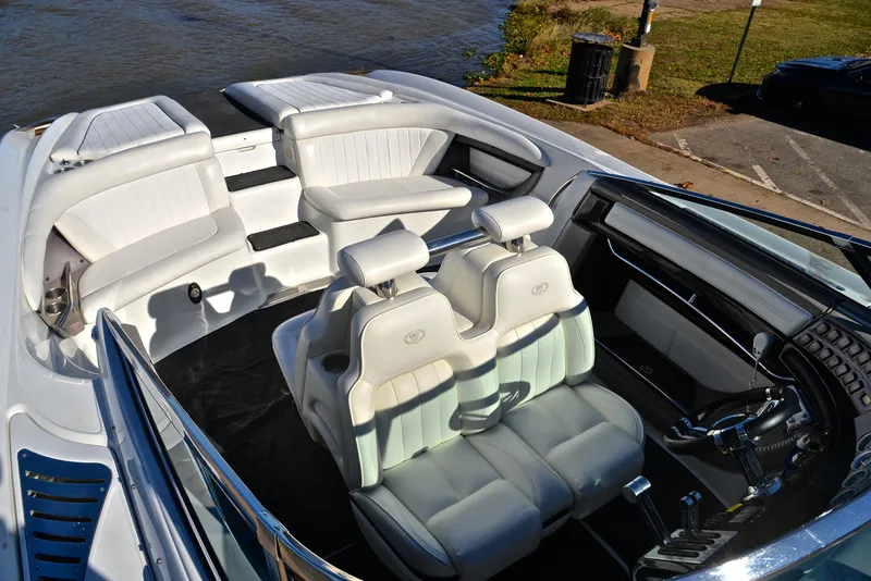 Slide: The Image of 2005 Cobalt 343 boat interior with white leather seats, near water. - 25