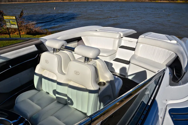 Slide: The Image of 2005 Cobalt 343 boat interior with white leather seats by a lake. - 26