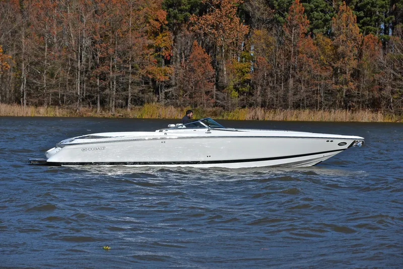 Slide: The Image of 2005 Cobalt 343 boat cruising on a lake with autumn trees in the background. - 9
