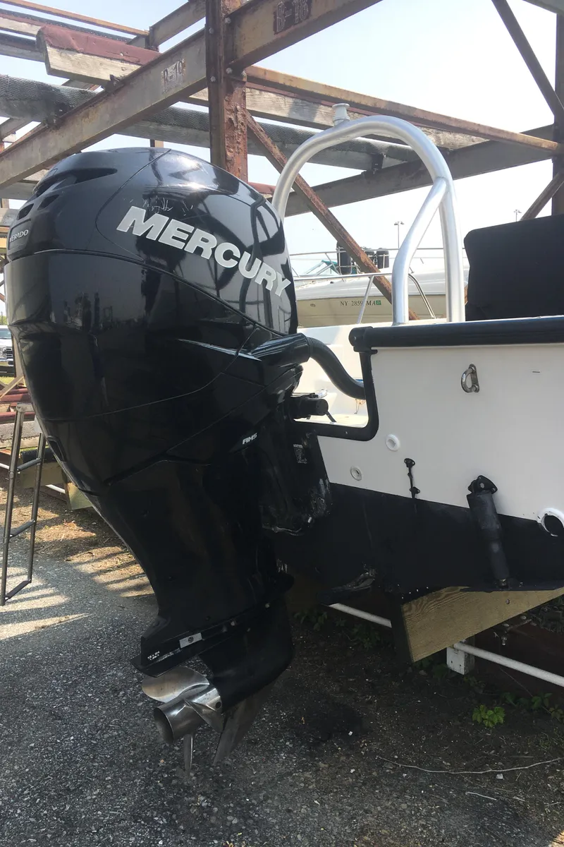 Slide: The Image of 2015 Boston Whaler 210 Montauk with Mercury outboard engine, docked on a metal frame. - 23