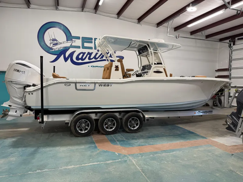 Slide: The Image of 2025 Key West 291FS boat on trailer in indoor showroom. - 1
