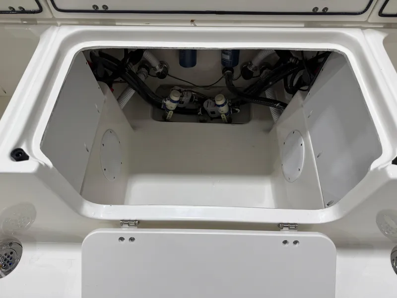Slide: The Image of 2025 Key West 291FS boat storage compartment with visible wiring and plumbing. - 18