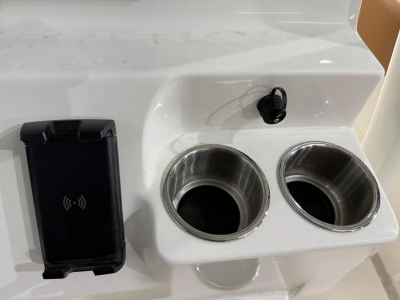 Slide: The Image of 2025 Key West 291FS boat console with dual cup holders and phone charging dock. - 32