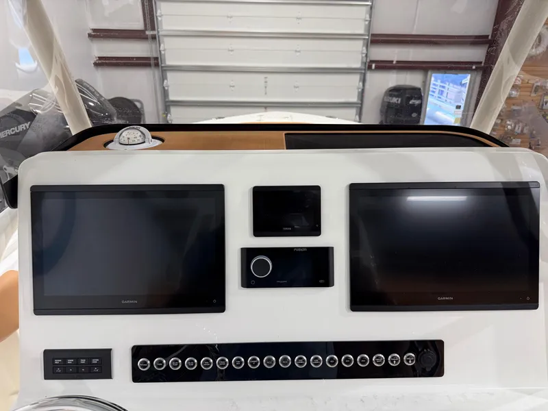 Slide: The Image of 2025 Key West 291FS boat dashboard with dual Garmin screens and control panel. - 34
