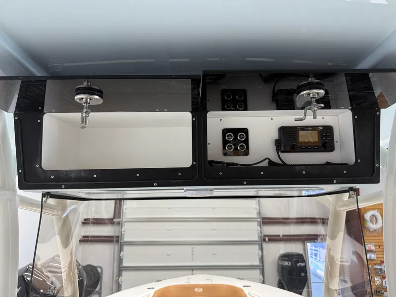 Slide: The Image of 2025 Key West 291FS boat console with radio and storage compartments. - 37
