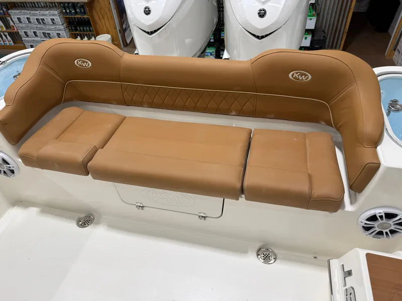 Slide: The Image of 2025 Key West 291FS boat with tan cushioned seating and integrated speakers. - 42