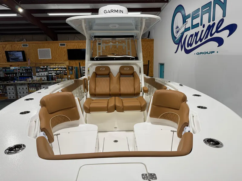 Slide: The Image of 2025 Key West 291FS boat interior with tan seating at Ocean Marine Group showroom. - 8