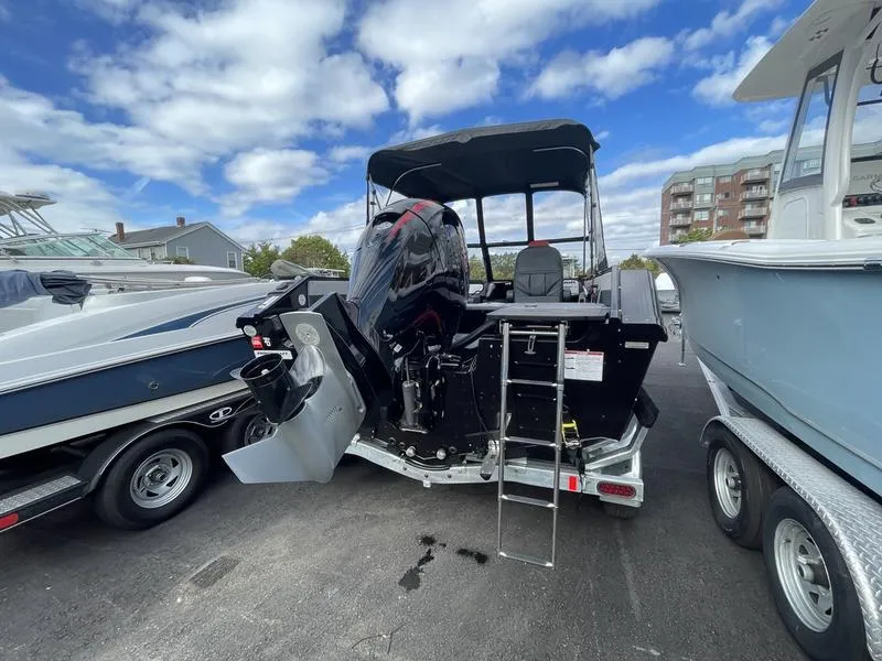 Slide: The Image of 2024 Princecraft AYB5258TS boat with outboard motor and ladder, parked at a marina. - 13