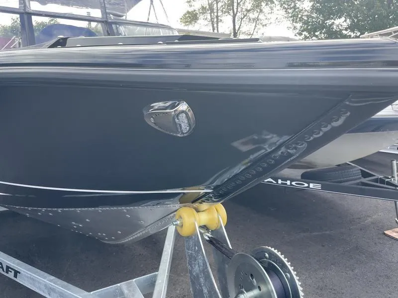 Slide: The Image of 2024 Princecraft AYB5258TS boat on trailer, sleek black hull design. - 2