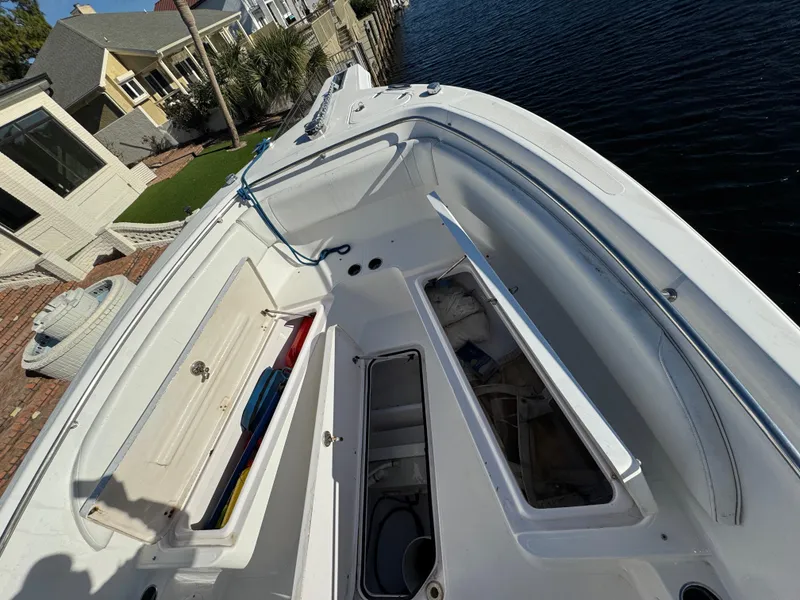 Slide: The Image of 2007 Pro-Line 29 Super Sport boat with open storage compartments docked by a waterfront home. - 10