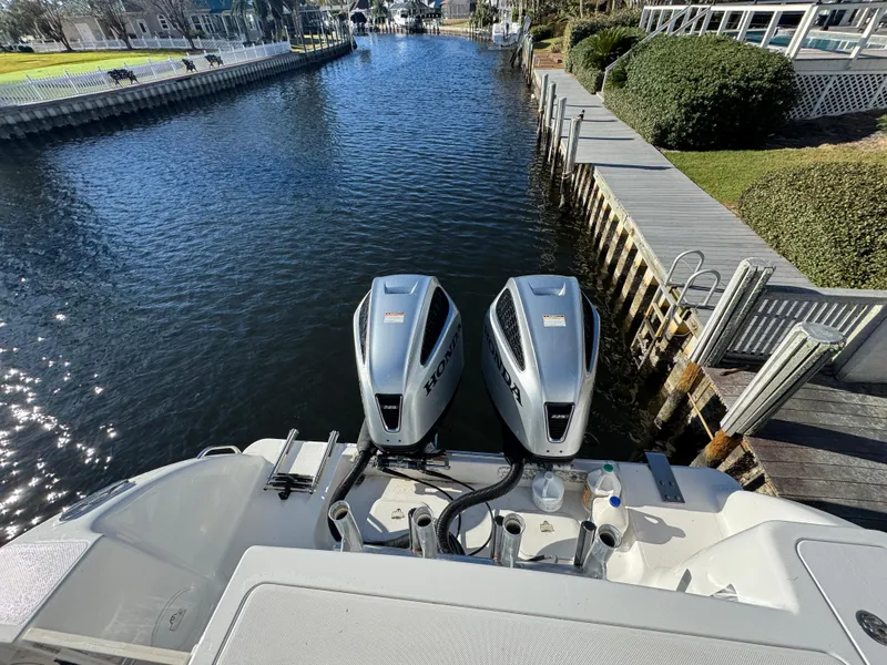 Slide: The Image of 2007 Pro-Line 29 Super Sport boat with dual engines docked by a canal. - 16