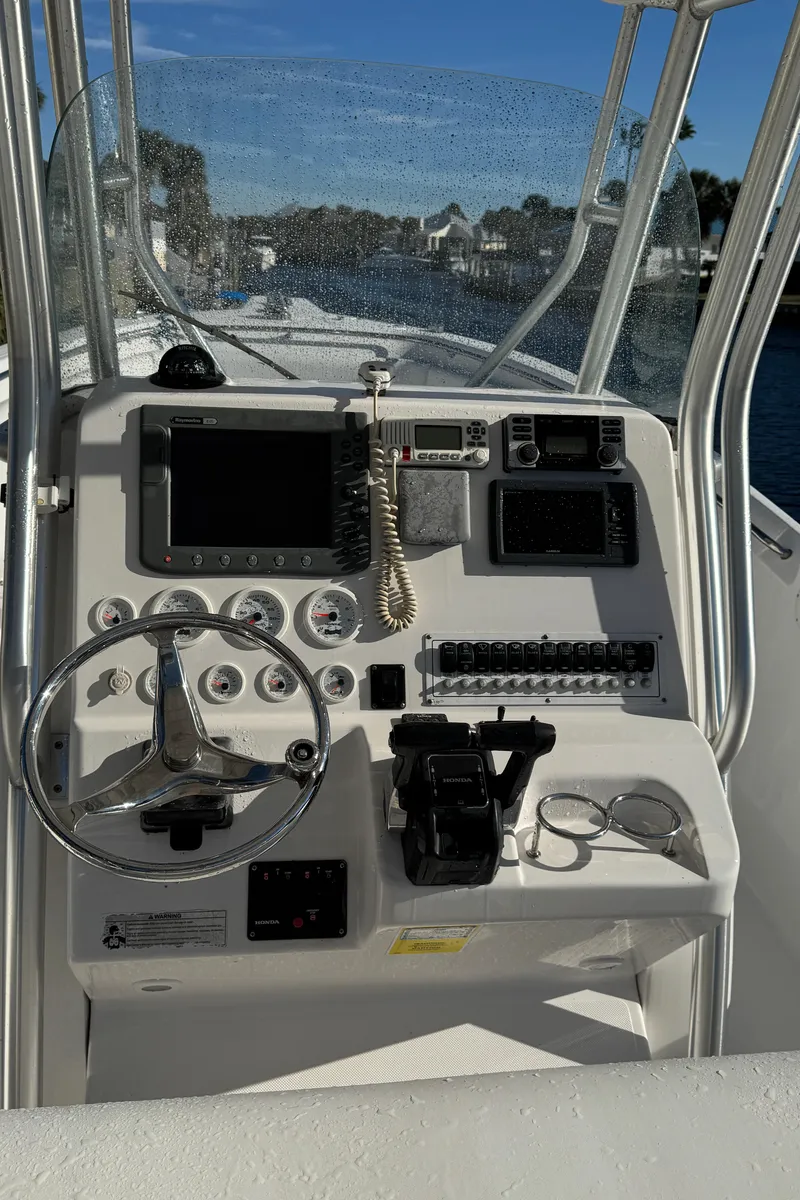 Slide: The Image of 2007 Pro-Line 29 Super Sport boat dashboard with steering wheel and navigation controls. - 26
