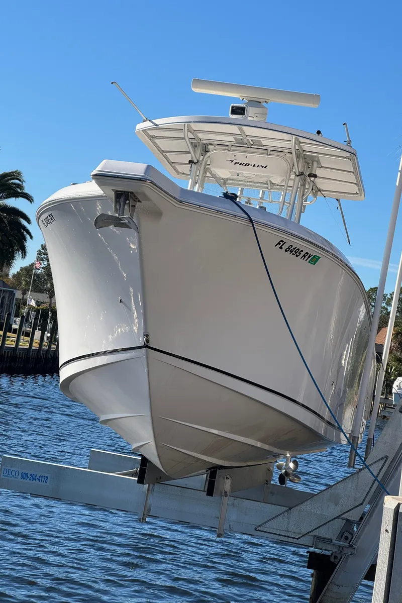 Slide: The Image of 2007 Pro-Line 29 Super Sport boat on lift by waterfront. - 4