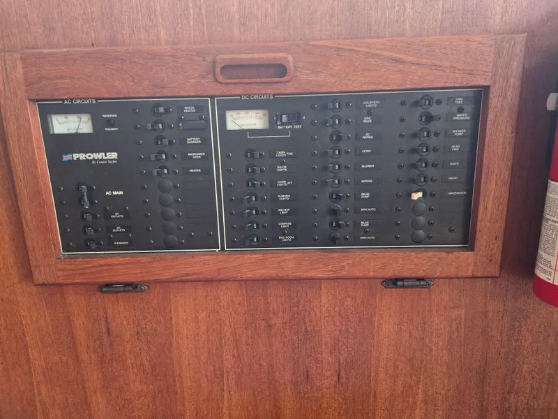 Slide: The Image of 1991 Cooper Prowler electrical panel with AC and DC circuits on wooden background. - 15