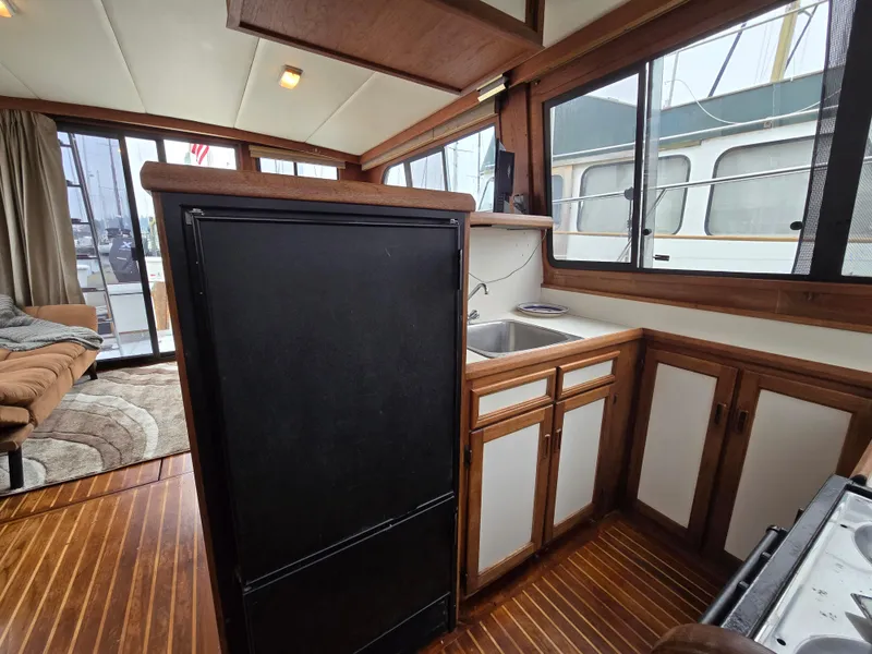 Slide: The Image of Interior of 1991 Cooper Prowler boat with kitchen area, wood flooring, and large windows. - 19