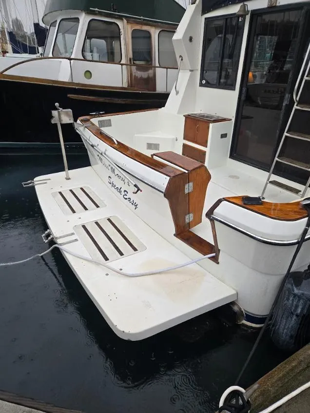 Slide: The Image of 1991 Cooper Prowler boat docked, featuring a white deck and wooden accents. - 2