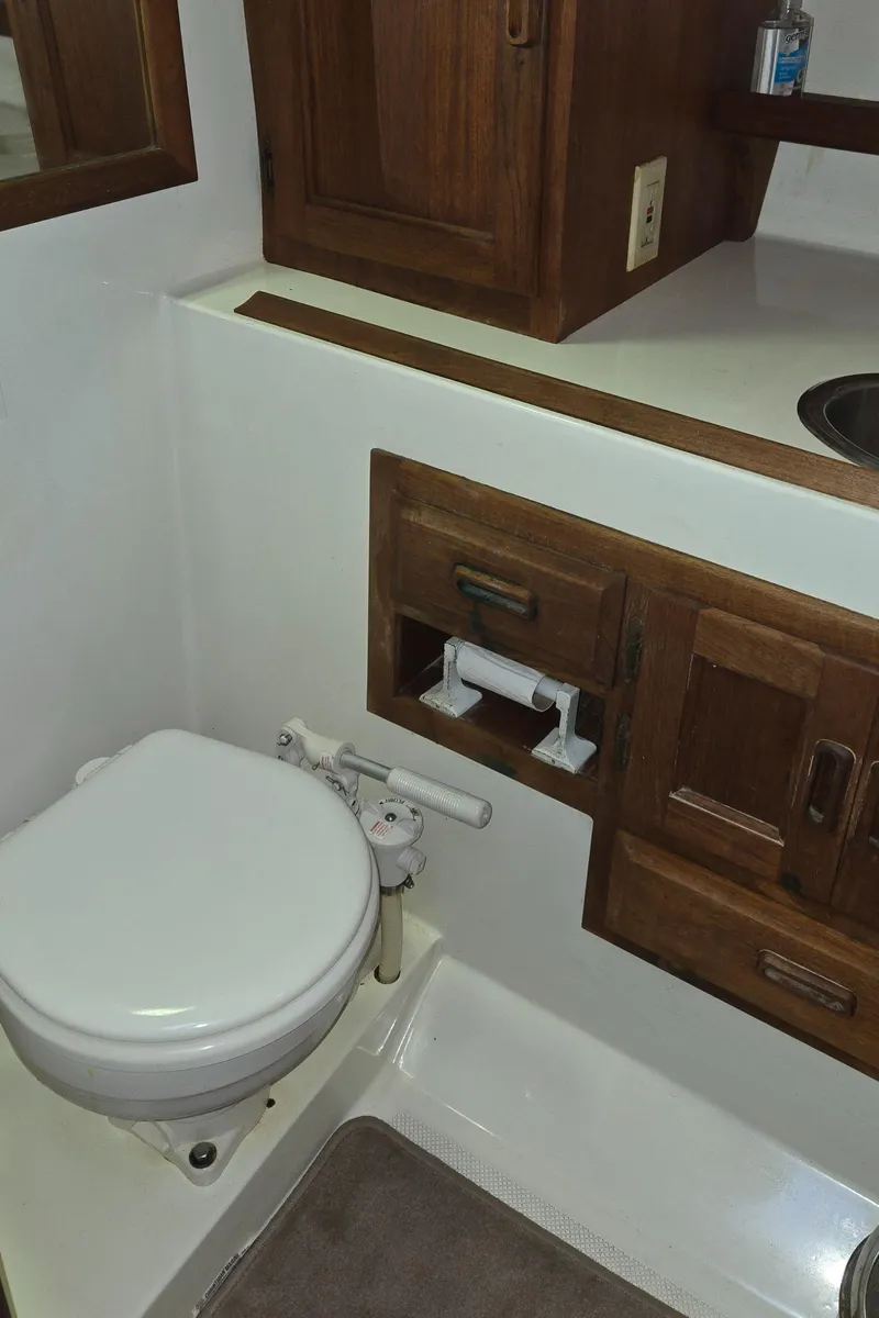 Slide: The Image of 1991 Cooper Prowler RV bathroom with wooden cabinets and compact toilet. - 22