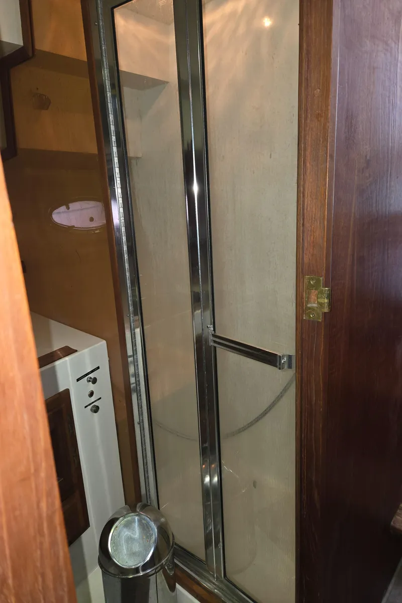 Slide: The Image of Shower area in 1991 Cooper Prowler boat with glass door and wooden accents. - 23