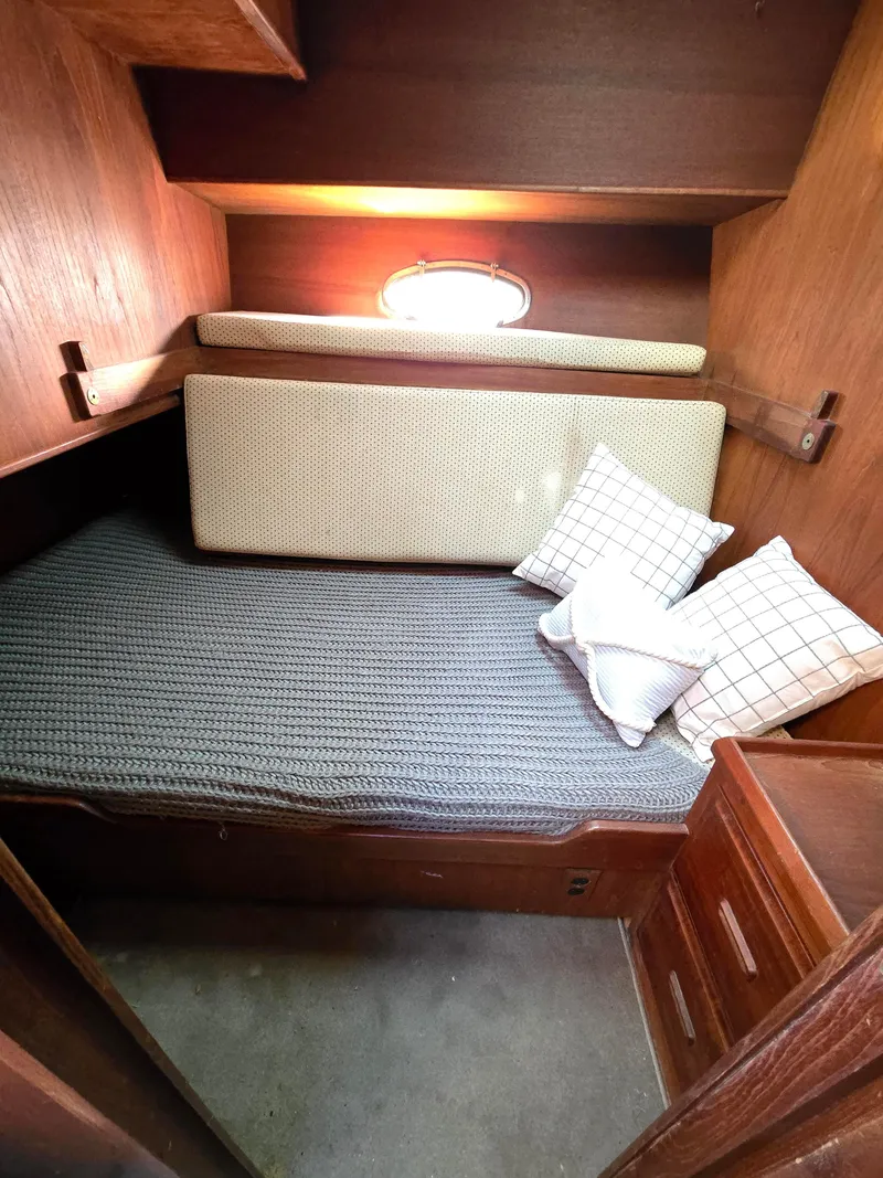 Slide: The Image of Cozy cabin interior of 1991 Cooper Prowler with bed, cushions, and wooden storage. - 28
