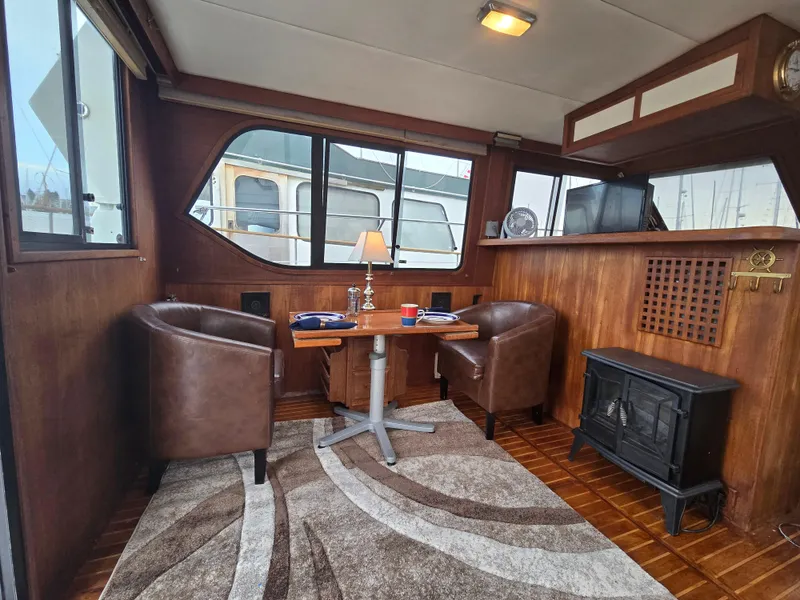 Slide: The Image of Cozy 1991 Cooper Prowler boat interior with leather chairs, table, and decorative lamp. - 8