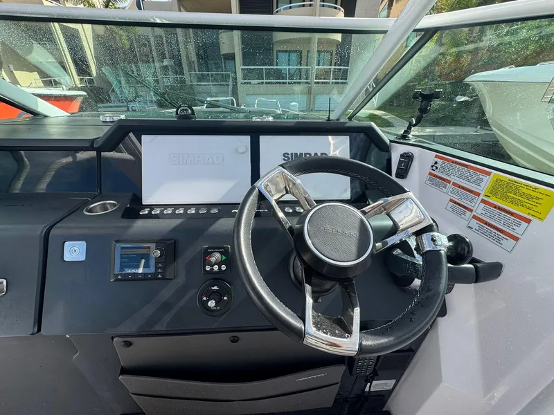 Slide: The Image of 2021 Axopar 37ST boat helm with steering wheel and Simrad displays. - 10