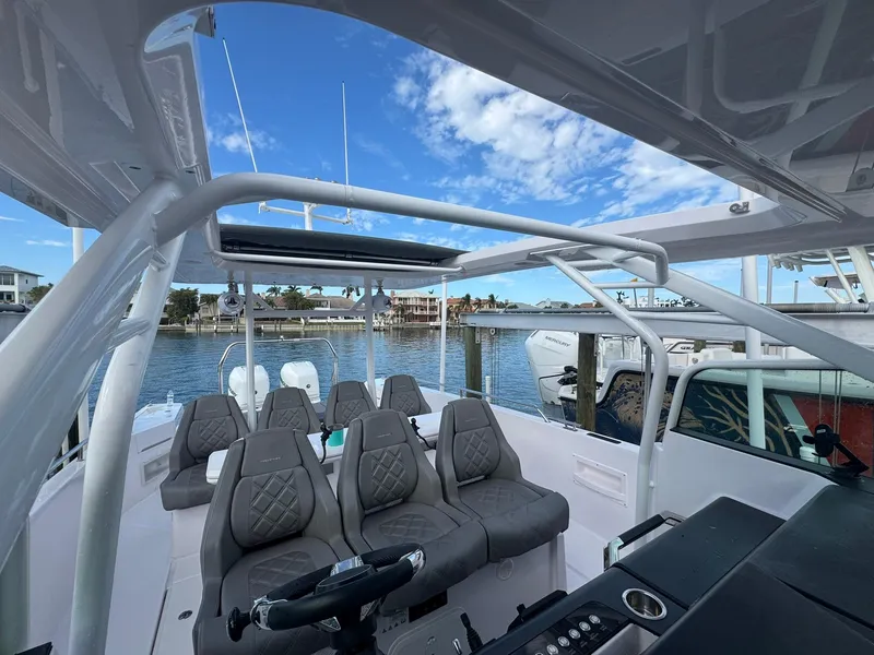 Slide: The Image of 2021 Axopar 37ST boat interior with seating and steering, docked by the water. - 13