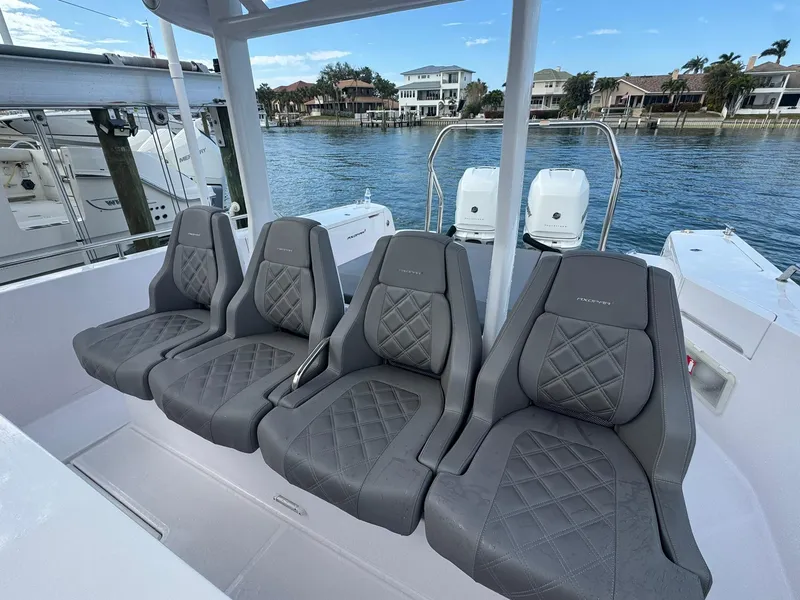 Slide: The Image of Axopar 37ST 2021 boat with luxurious gray seating, docked by waterfront homes. - 17