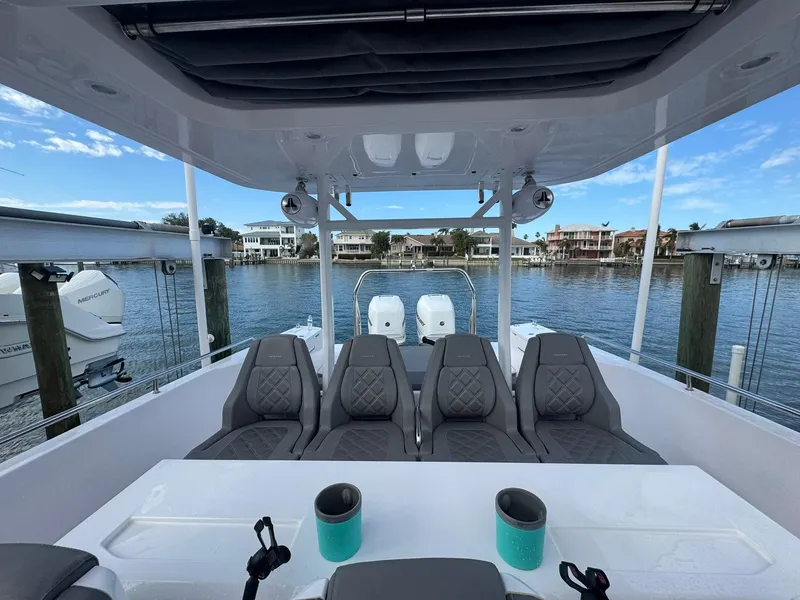 Slide: The Image of 2021 Axopar 37ST boat interior with seating, docked by waterfront homes. - 18