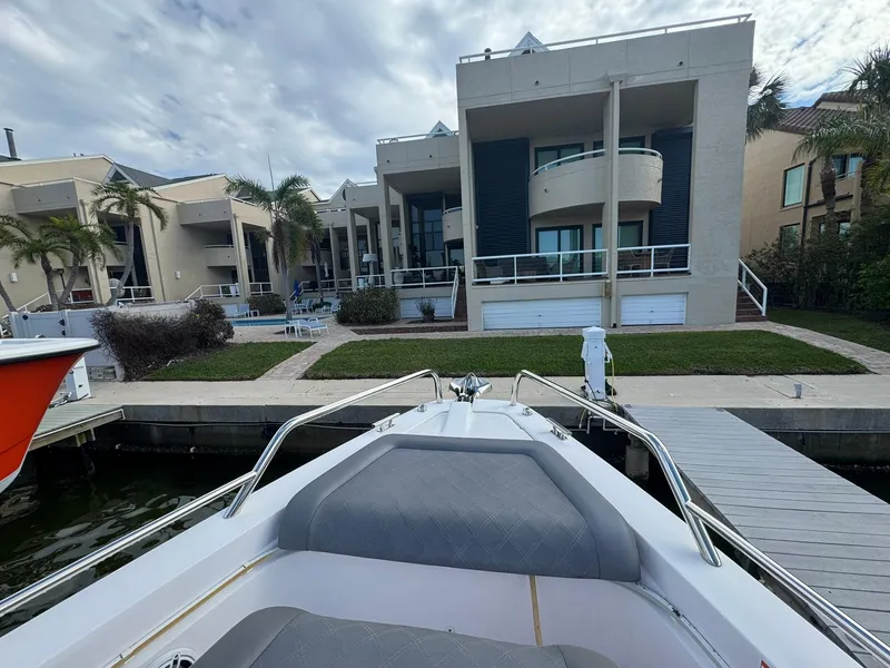 Slide: The Image of Axopar 37ST 2021 boat docked near modern waterfront homes under cloudy sky. - 21