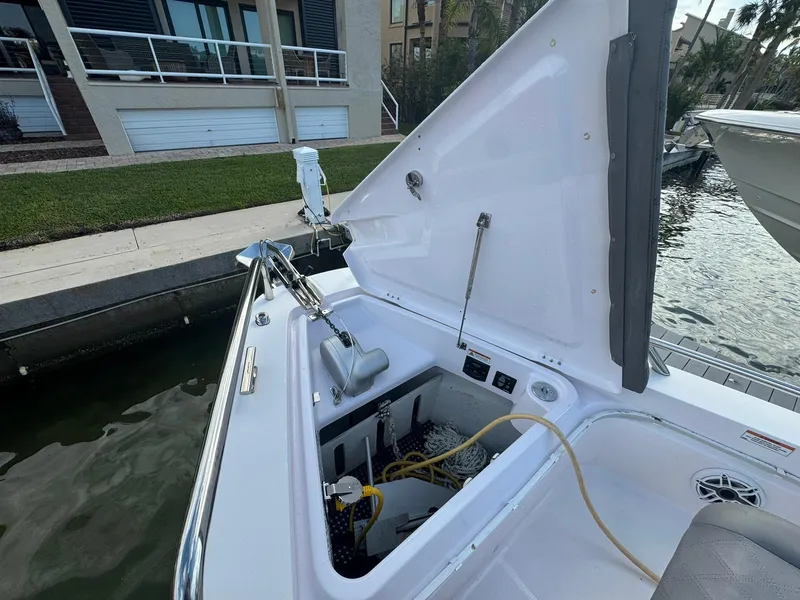 Slide: The Image of Axopar 37ST 2021 boat anchor compartment open, docked by waterfront homes. - 23