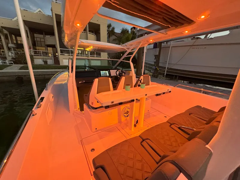 Slide: The Image of 2021 Axopar 37ST boat with ambient orange lighting at a dock. - 38