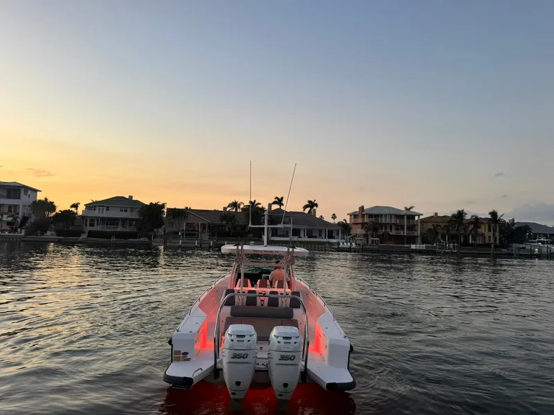Slide: The Image of Axopar 37ST 2021 boat on calm water at sunset, waterfront homes in background. - 4